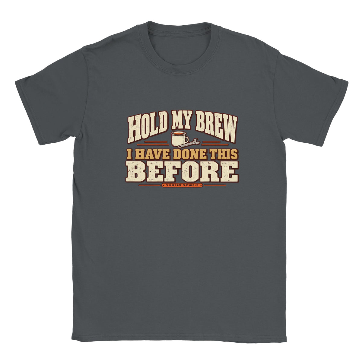 Front of a charcoal T-shirt with ‘Hold My Brew, I Have Done This Before’ lettering, a mug and spanner graphic, and Clocked Off Clothing Co. branding.