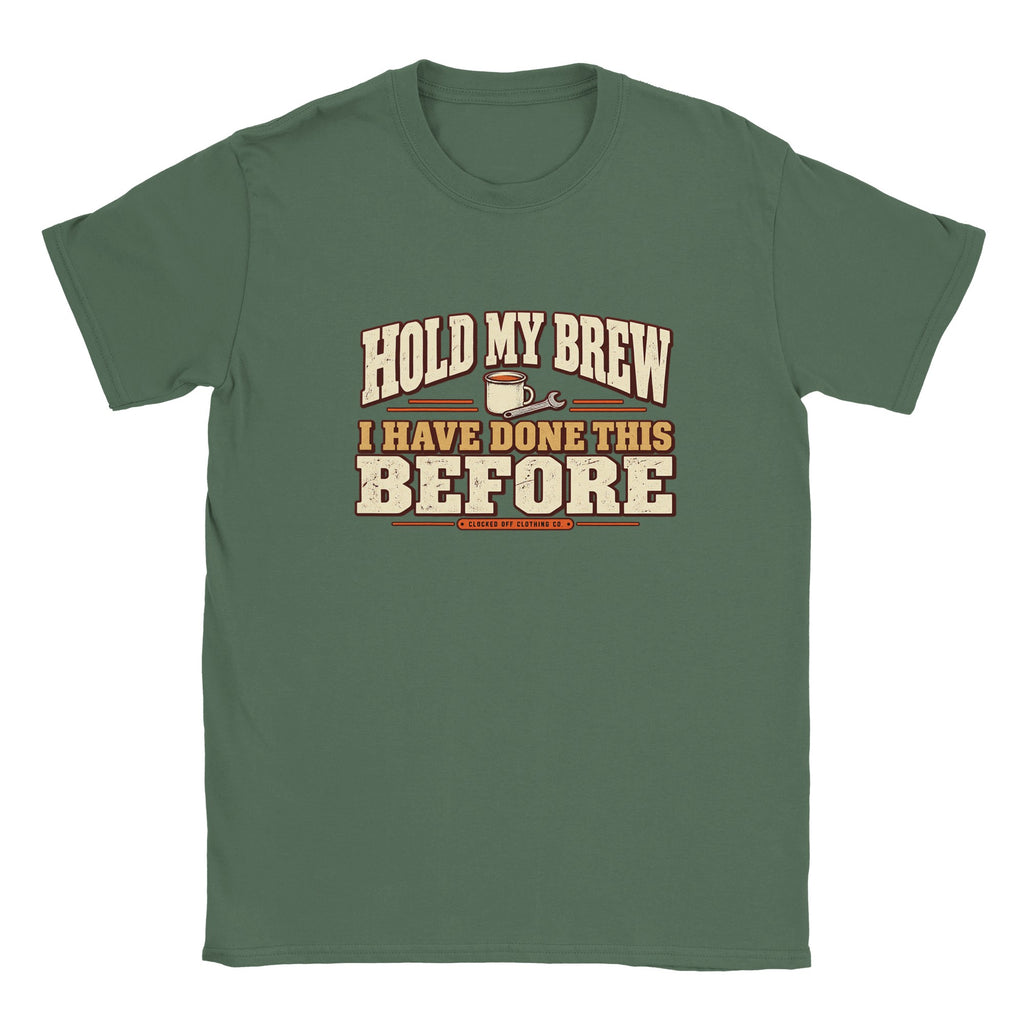 Front of a military green T-shirt with ‘Hold My Brew, I Have Done This Before’ lettering, a mug and spanner graphic, and Clocked Off Clothing Co. branding.